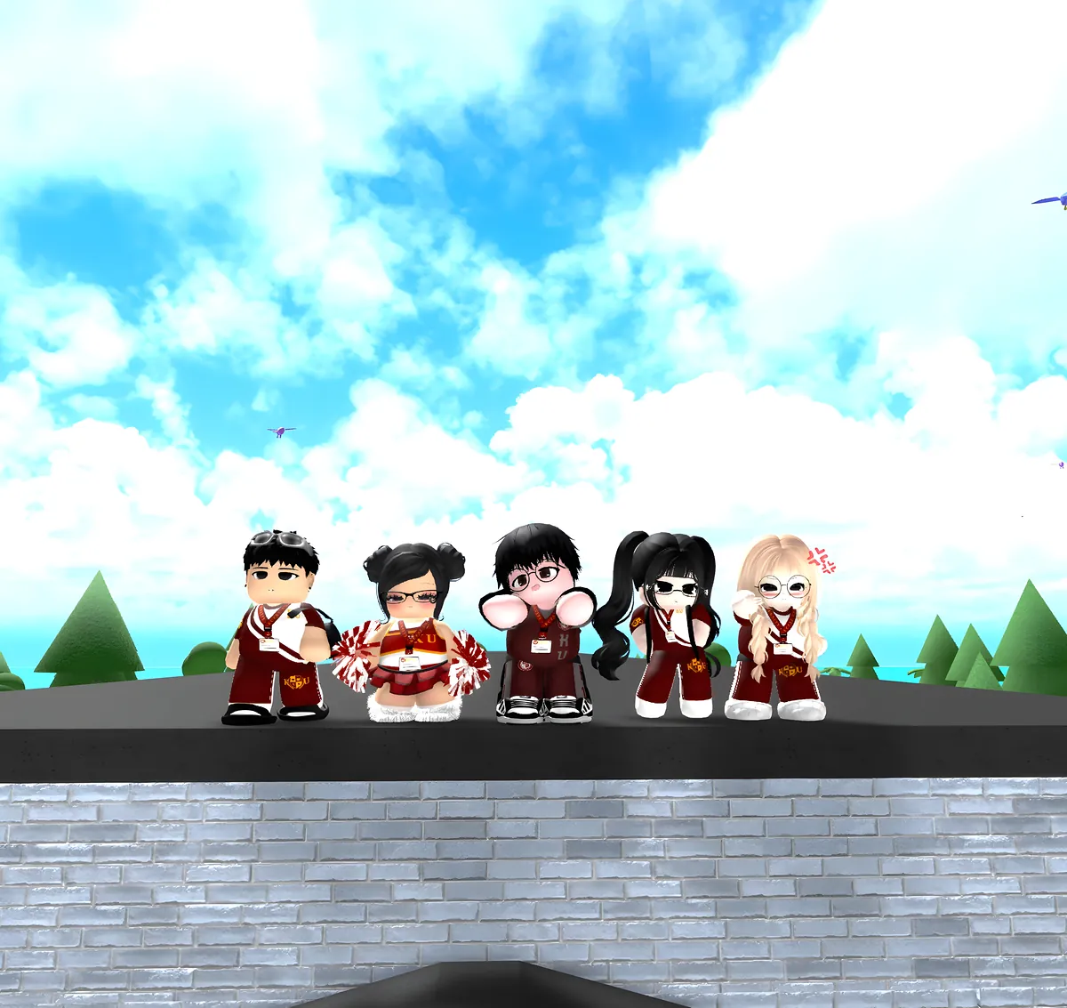 Five friends in KU uniforms standing on a rooftop under a bright, cloudy sky, one holding cheer pom-poms