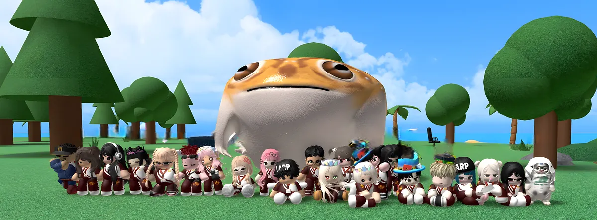A huge group in maroon KU uniforms sitting on the grass in front of a giant smiling fish